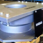 A heavy-duty Hercules spherical bearing, showing its silver steel plates and bolted assembly, ready for installation in a bridge or large structure.