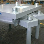 Close-up of a guided sliding structural bearing component, showing the low-friction surface and a central guide rail.