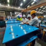 A technician carefully overseeing the production process of elastomeric bearing pads.