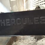 The embossed Hercules brand name on the side of a finished black elastomeric bearing.