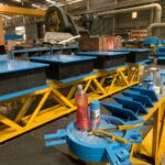 A large, yellow steel structural assembly being prepared for the installation of bearings.