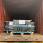 Pallets loaded with Hercules elastomeric bearing pads being secured inside a shipping container for delivery.