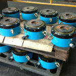 A pallet stacked with finished hydraulic jacks, showcasing a set of ready-to-use bridge construction equipment.